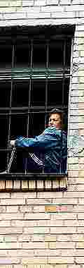 woman sitting alone in a barred window