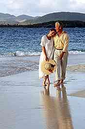 couple walking on beach while embracing
