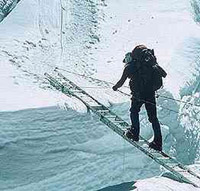 man crossing ice chasm on a ladder